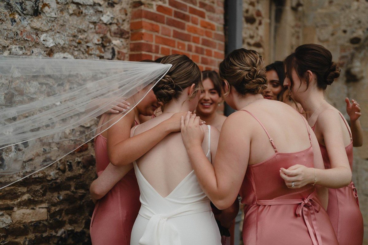 Bride hugging bridesmaids