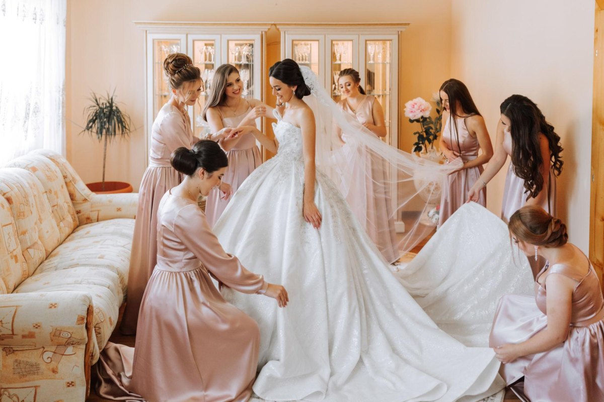 Bridesmaids helping bride prepare