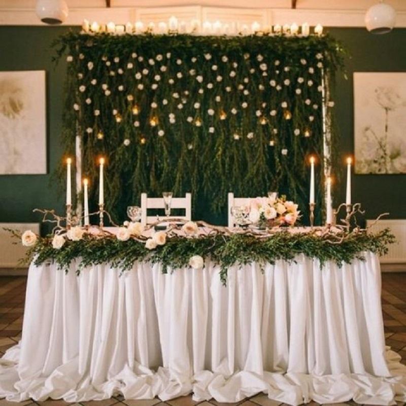Wedding backdrop decorated with candles and greenery