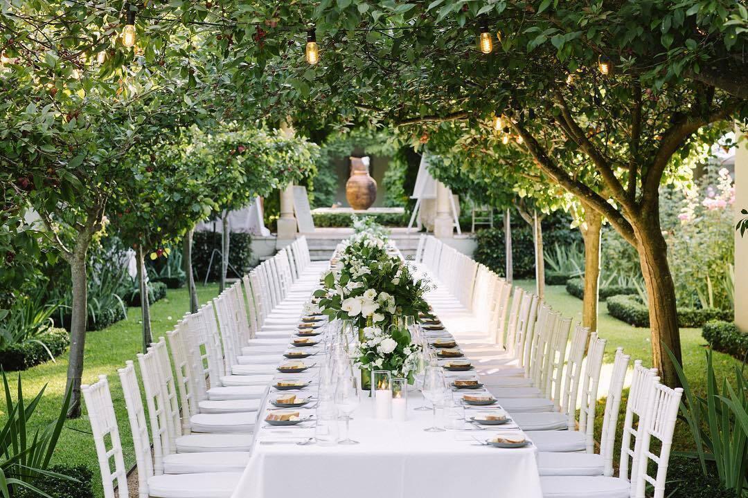 Dining tables beneath garden trees