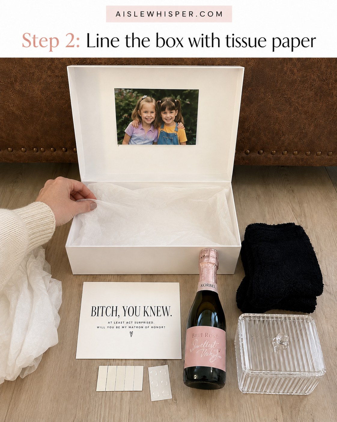 Hand lining a matron of honor proposal box with white tissue paper before packing