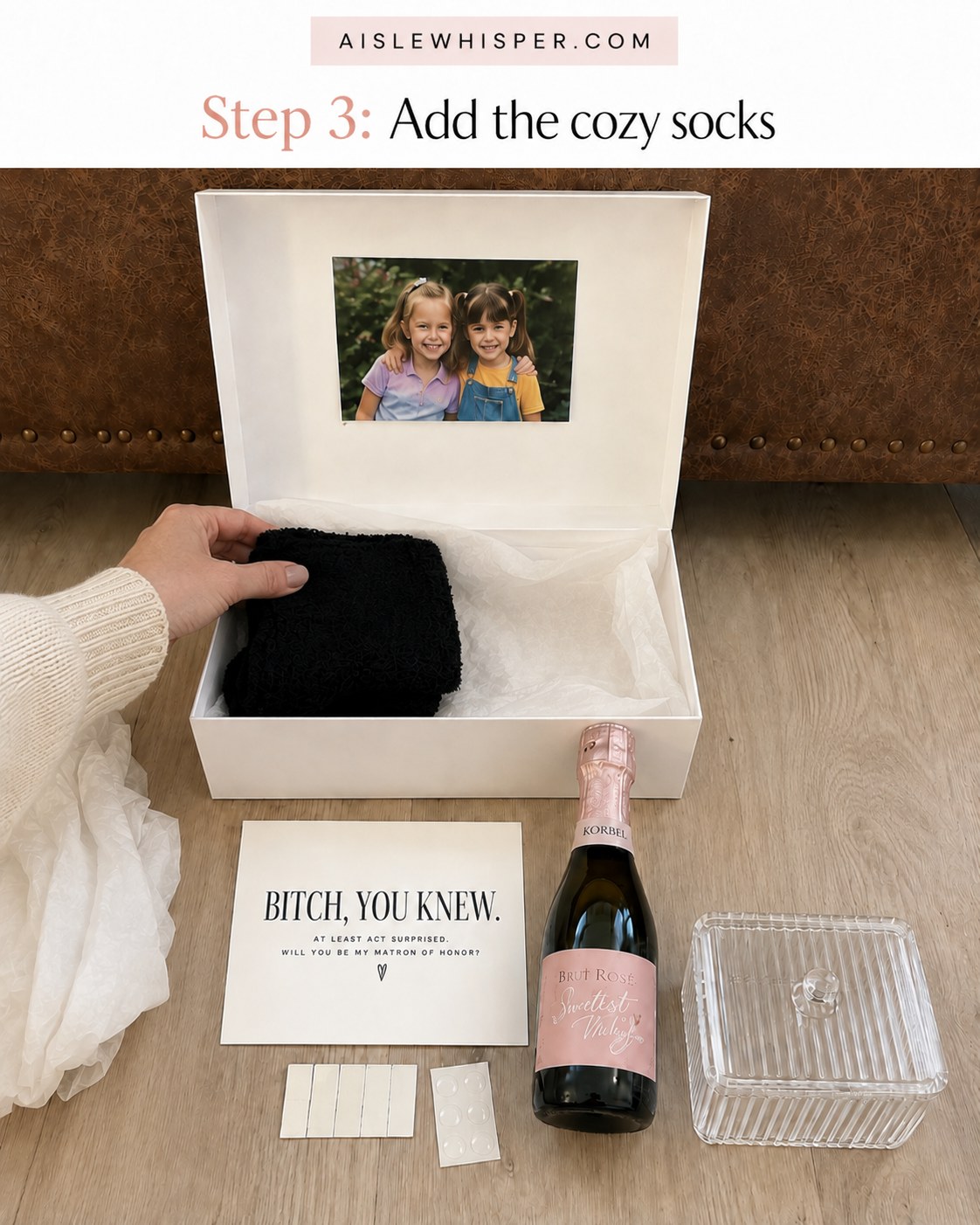 Black cozy socks being placed inside a matron of honor proposal box for cushioning