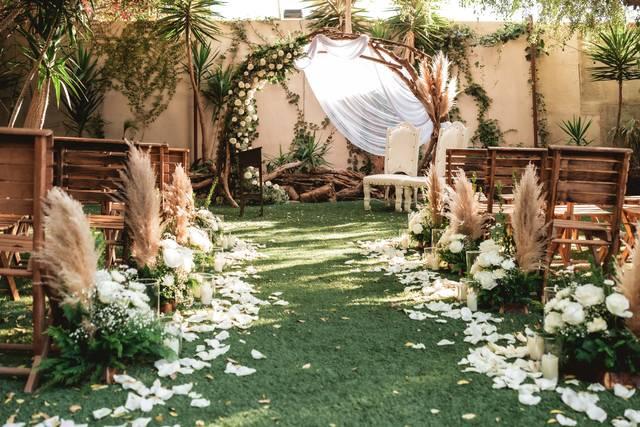 Greenery decorated backyard wedding aisle