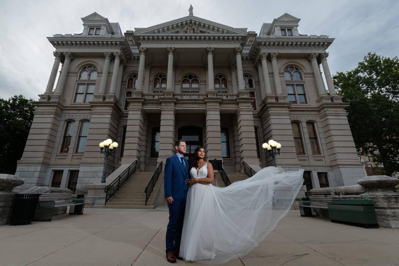 Newlyweds near historic courthouse architecture