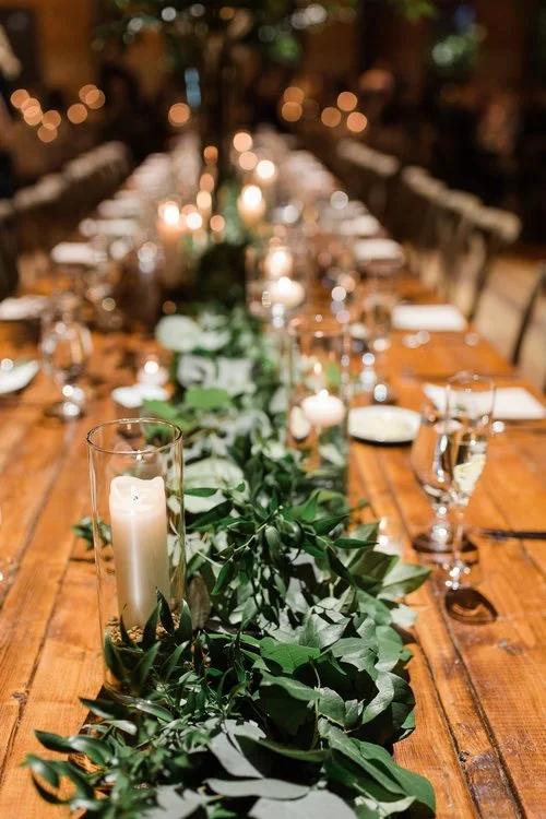 Rustic wedding table with candles and greenery