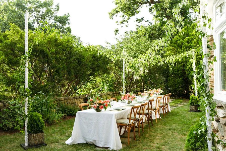 Elegant garden reception table beside greenery